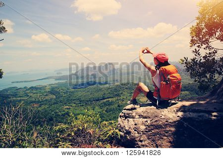 woman hiker enjoy the view on mountain top cliff