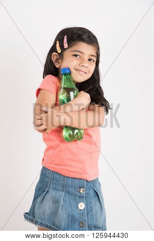 indian girl with cold drink bottle, asian girl drinking cold drink in pet bottle, girl kid and cold drink, indian cute girl with lemon or transparent juice in plastic bottle, isolated on white