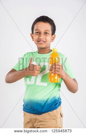 indian boy with cold drink bottle, asian boy holding cold drink bottle, small boy and cold drink, indian cute boy drinking mango juice or orange juice in plastic bottle