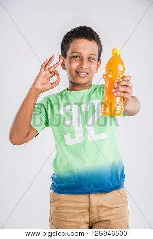 indian boy with cold drink bottle, asian boy holding cold drink bottle, small boy and cold drink, indian cute boy drinking mango juice or orange juice in plastic bottle