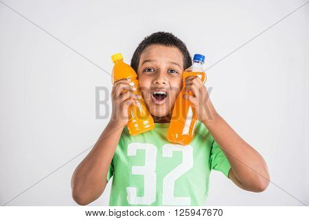 indian boy with cold drink bottle, asian boy holding cold drink bottle, small boy and cold drink, indian cute boy drinking mango juice or orange juice in plastic bottle