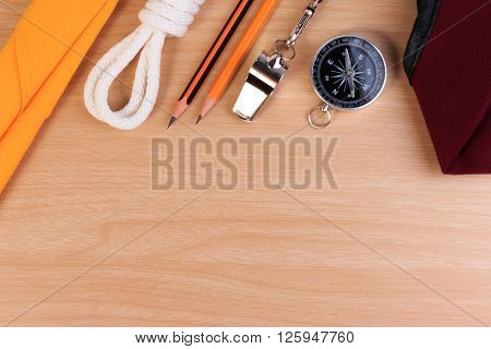 Orderliness White Scout Rope, Scarf, Whistle, Pencil, Compass And Red Beret On Wooden Table.