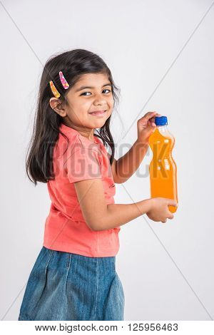 indian girl with cold drink bottle, asian girl drinking cold drink in pet bottle, girl kid and cold drink, indian cute girl with mango or orange cold drink in plastic bottle, isolated