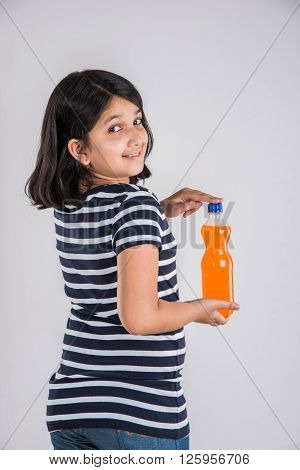 indian girl with cold drink bottle, asian girl drinking cold drink in pet bottle, girl kid and cold drink, indian cute girl drinking mango juice or orange juice in plastic bottle