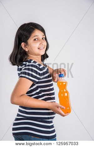 indian girl with cold drink bottle, asian girl drinking cold drink in pet bottle, girl kid and cold drink, indian cute girl drinking mango juice or orange juice in plastic bottle