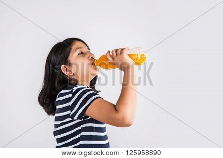 indian girl with cold drink bottle, asian girl drinking cold drink in pet bottle, girl kid and cold drink, indian cute girl drinking mango juice or orange juice in plastic bottle