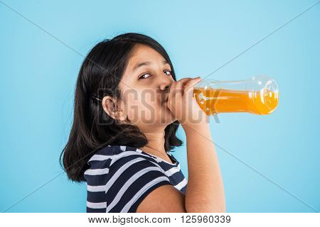 indian girl with cold drink bottle, asian girl drinking cold drink in pet bottle, girl kid and cold drink, indian cute girl drinking mango juice or orange juice in plastic bottle