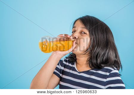 indian girl with cold drink bottle, asian girl drinking cold drink in pet bottle, girl kid and cold drink, indian cute girl drinking mango juice or orange juice in plastic bottle