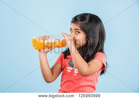 indian girl with cold drink bottle, asian girl drinking cold drink in pet bottle, girl kid and cold drink, indian cute girl with mango or orange cold drink in plastic bottle, isolated