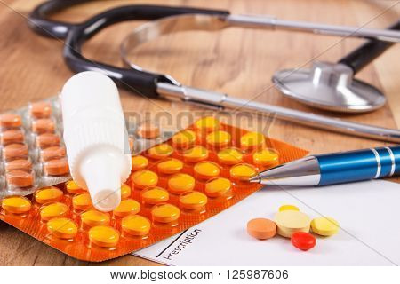 Medical pills tablets or supplements for therapy prescription and stethoscope on desk in doctor office concept of treatment