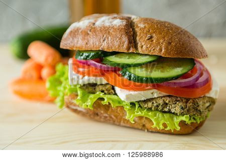 Vegan sandwich in lunch box with carrots and nuts - healthy food to go concept, wood background, copy space
