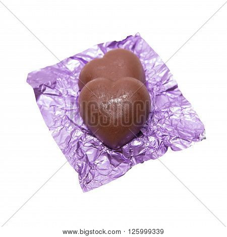 Two chocolate heart candy in puple foil on white background
