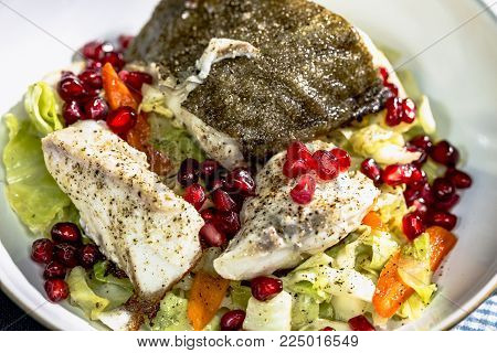 Skrei winter cod with skin roasted on braised pointed cabbage with pomegranate seeds