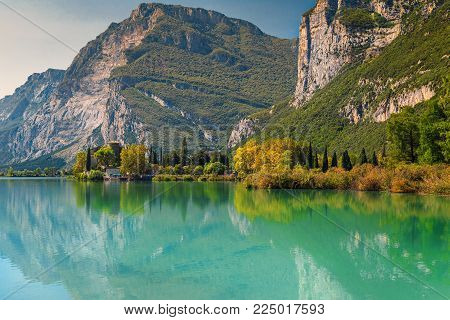Spectacular Toblino lake with high mountains and medieval Castle Toblino in background near Garda lake, Trentino Alto Adige, Italy, Europe