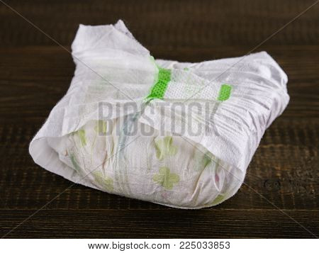 dirty diaper on dark wooden background, selective focus