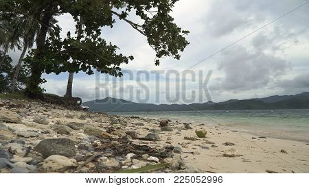 Wild beautiful beach with sand and coconut palms. Tropical bay in El Nido. Sky and mountains rocks. . Seascape: mountains, ocean., beach. Philippines, El Nido Travel concept