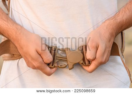 A Young Man Demonstrates Fastex Buckle In Action From The Waist Belt Of A Backpack