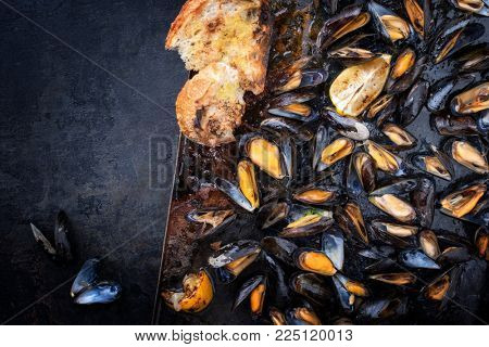 Traditional barbecue Italian blue mussel as top view on a metal sheet 