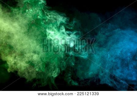 Thick colorful smoke of  purle and pink on a black isolated background. Background from the smoke of vape