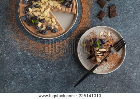 Raw vegan chocolate-caramel cheesecake with blueberries, raw candy balls and almonds. Healthy vegan food concept.