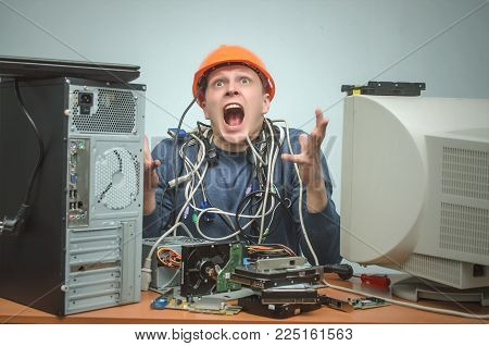 Overloaded computer repairman tired from his work and goes crazy. Computer technician. PC repair service center.