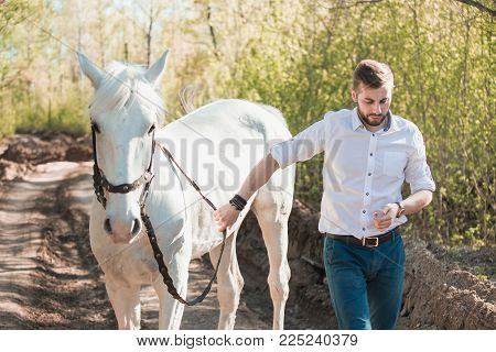 Young Man With A Horse. Autumn Outdoors Scene