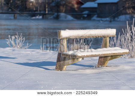 a cold and frozen bench covered in snow near Karlskoga sweden
