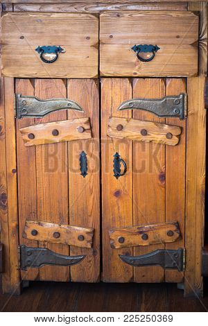 Antique solid wooden Cabinet with doors and drawers. Black metal forged fittings