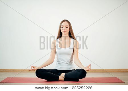 Young Woman Meditates While Practicing Yoga. Freedom Concept