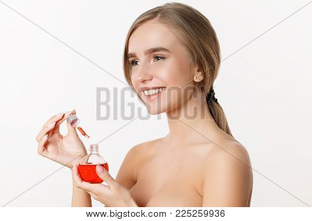 Portrait of beautiful model applying a skin serum treatment. Perfect skin. Isolated on the white background