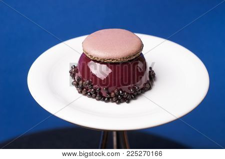 Three berries cake dessert with macarron almond cake biscuit chocolate vanilla cream, chocolate mousse jam from berry fruit on white plate, close-up