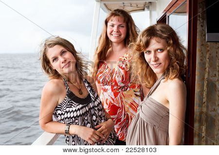 Trois belles jeunes femmes A Caucasiens, debout ensemble sur le pont du Yacht de croisière
