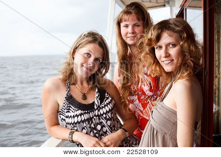 Trois belles jeunes femmes A Caucasiens, debout ensemble sur le pont du Yacht de croisière