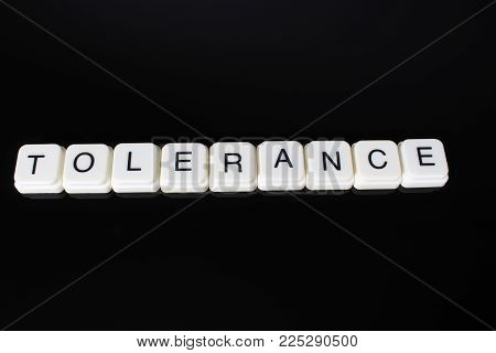 Tolerance text word title caption label cover backdrop background. Alphabet letter toy blocks on black reflective background. White alphabetical letters..