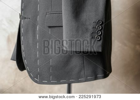 Semi-ready suit on tailor mannequin against light background