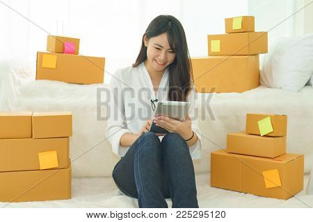 Asian young woman business work at home for online shopping and sale.small and medium enterprise business
