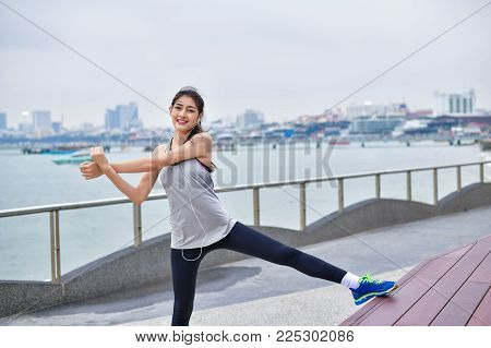 Sports concept. Beautiful girl is exercising on the beach with warm up. Beautiful girl is happy to exercise. 
Beautiful girls like to exercise by warm up. People are exercising on the beach.