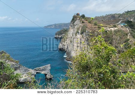 Rock in the ocean at Atuh beach on Nusa Penida island, Indonesia. Rocks in a blue sea lagoon with breaking waves. Travel concept