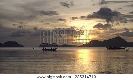 Marine tropical sunset over the sea. Sunset over the sea in the background boats, orange sky and islands. Travel concept. Nothing but sky, clouds and water. Beautiful serene scene.