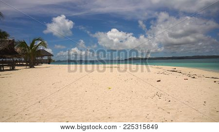 Beach with white sand with beach house on a tropical island Daco. Beautiful sky, sea, resort. Seascape: Ocean and beautiful beach paradise. Philippines. Travel concept.