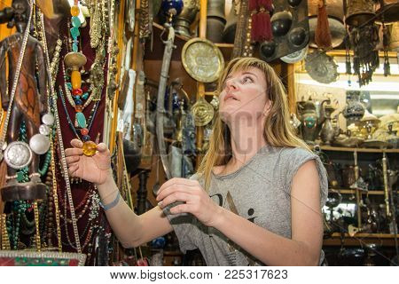 Akaba, Jordan -December, 23: Female tourist is buying a souvenir in an antique shop