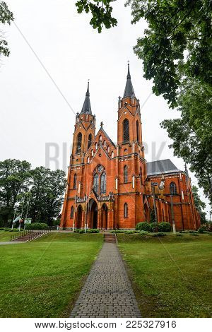 Rajgrod, Poland - August 22, 2017: Ancient Church Made From Red Briks And  Peaceful Church Park In L