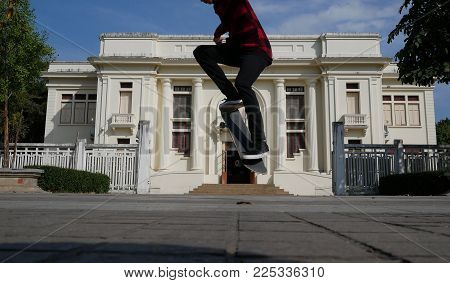 Skateboarder Skate & Jump Outdoors In Front Of Beige Building. Man On Skateboard. Sport Leisure Life