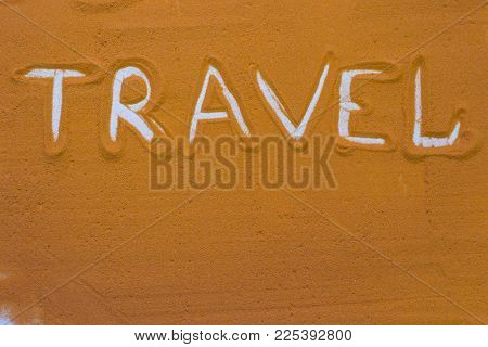 Travel Inscription On An Orange Colored Sand. Travel, Inspiration Concept Background With Copy Space