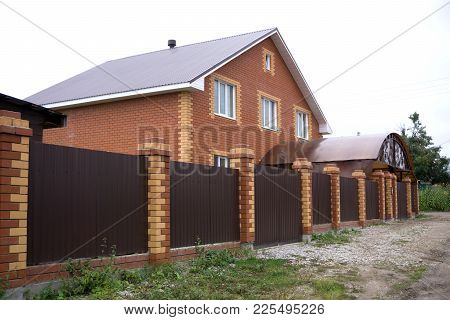 Brick House In Suburbs With Two Car Garage