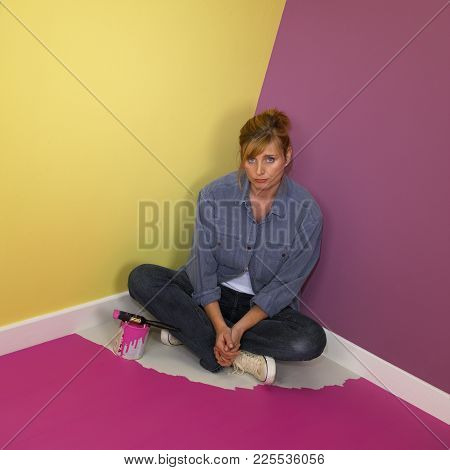 Cleckheaton, West Yorkshire, Uk: Attractive Young Blond Woman Trapped In Corner Of Room By Wet Paint
