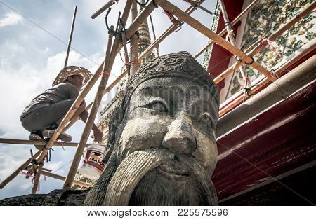 Bangkok, Thailand Noverber 29, 2017 : A Repairman Is Repairing A Roof In Wat Pho With A Giant Statue