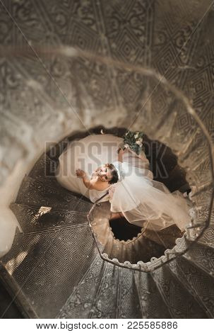 Beautiful Bride In Magnificent Dress Stands Alone On Stairs.