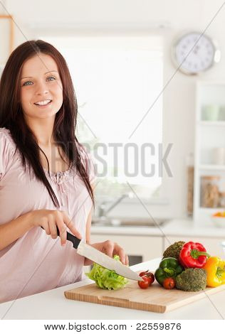 Vegetabels は台所でスライス笑顔の女性