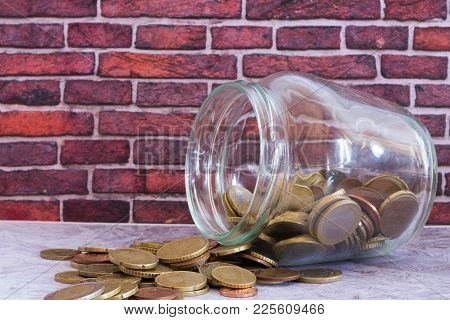 Several Coins And A Glass Jar Full Of Money
